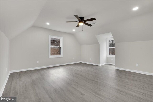 additional living space featuring lofted ceiling, visible vents, baseboards, and wood finished floors