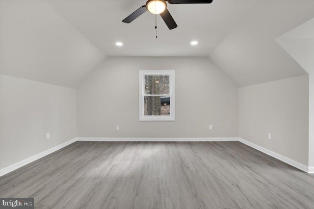 bonus room featuring vaulted ceiling, baseboards, and wood finished floors