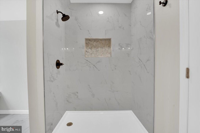 bathroom featuring marble finish floor, walk in shower, and baseboards