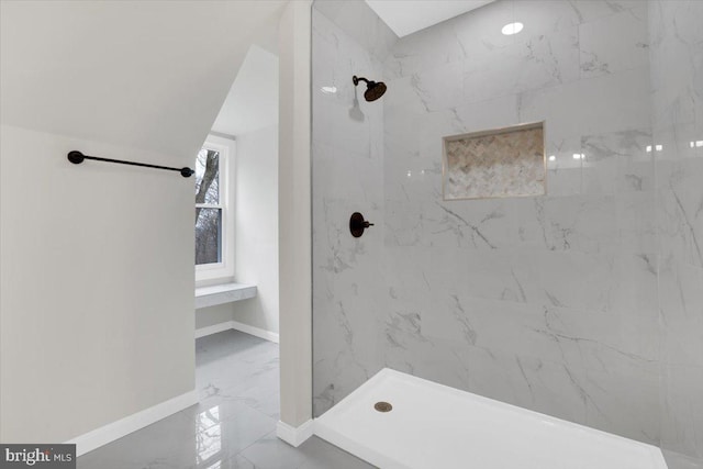 bathroom with marble finish floor, a marble finish shower, and baseboards