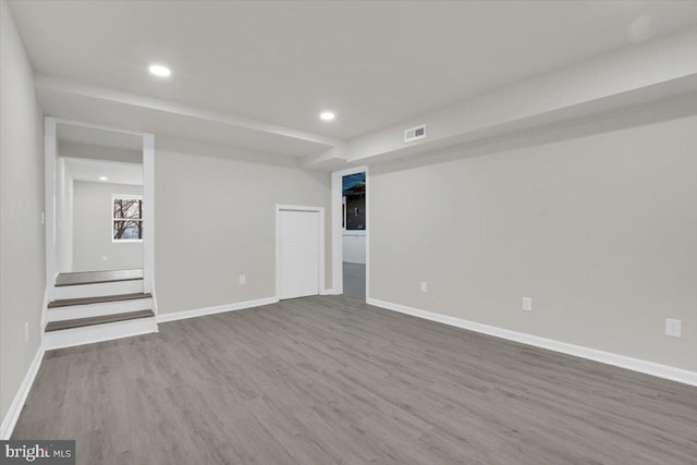 empty room featuring baseboards, visible vents, wood finished floors, and recessed lighting