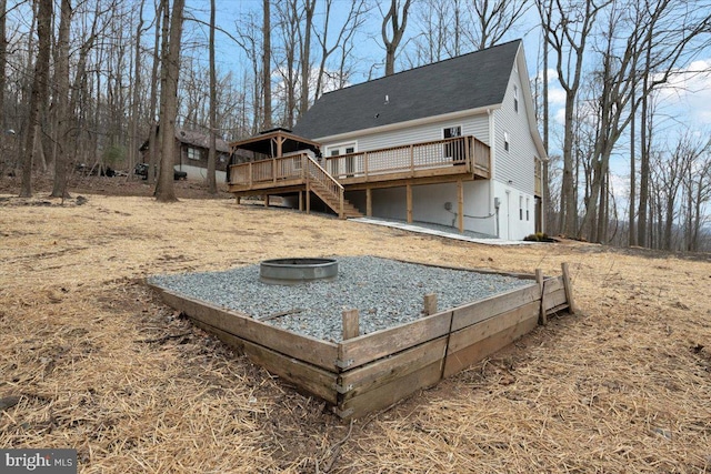 rear view of property featuring an outdoor fire pit, stairway, and a wooden deck