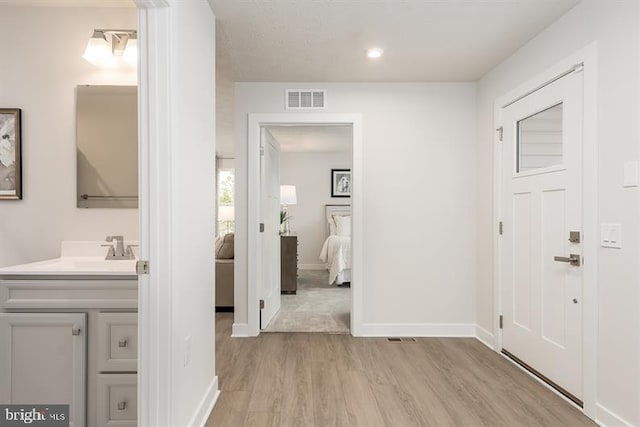 interior space featuring light wood-type flooring, visible vents, baseboards, and recessed lighting