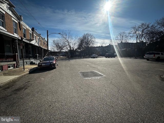 view of street with curbs, street lighting, sidewalks, and a residential view