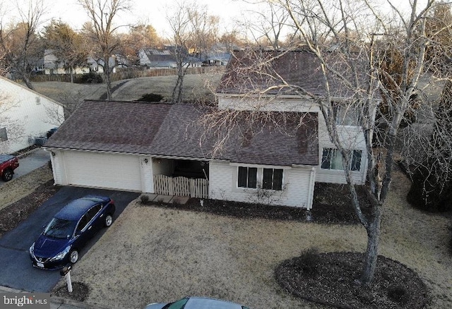 view of front of house featuring driveway, roof with shingles, and an attached garage