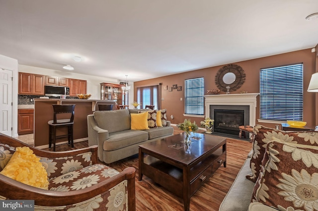 living area with a fireplace with flush hearth and light wood-style flooring