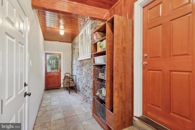 foyer entrance with stone finish floor and wooden ceiling