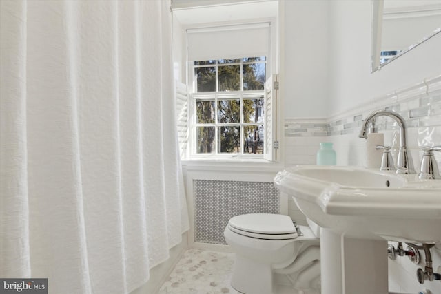 full bath featuring wainscoting, toilet, radiator heating unit, tile patterned floors, and tile walls