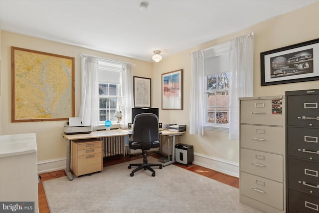 office space featuring radiator heating unit, baseboards, and wood finished floors