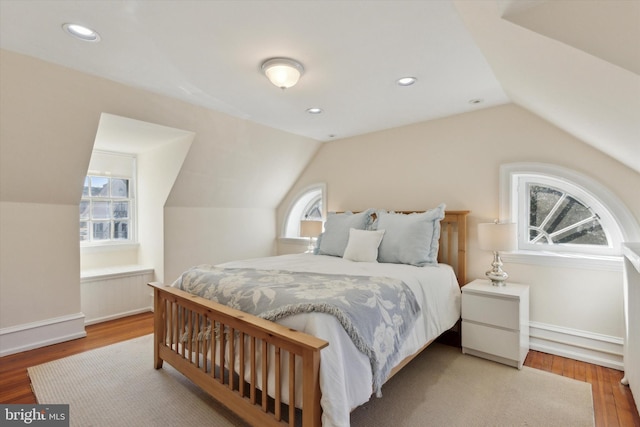 bedroom featuring multiple windows, vaulted ceiling, wood finished floors, and recessed lighting