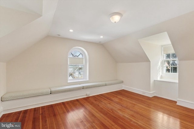 additional living space featuring lofted ceiling, baseboards, and wood finished floors