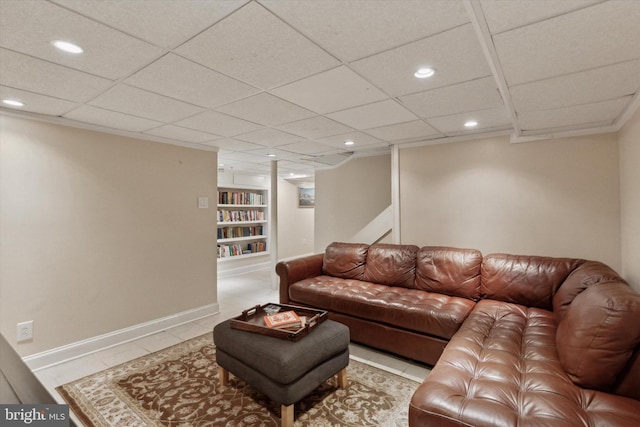 tiled living area with built in features, recessed lighting, a paneled ceiling, and baseboards