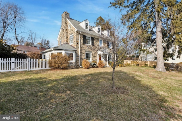 view of property exterior featuring stone siding, a chimney, fence, and a yard