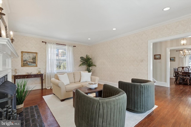 living area with a fireplace, wood finished floors, ornamental molding, wallpapered walls, and an inviting chandelier