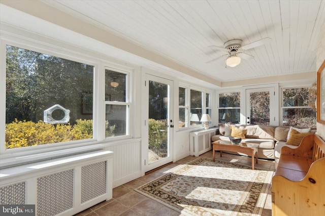 sunroom / solarium with wooden ceiling, radiator heating unit, and ceiling fan