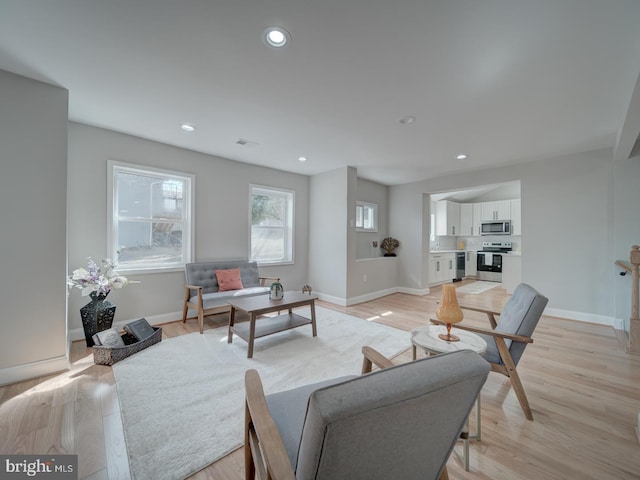 living room with visible vents, light wood-style flooring, recessed lighting, and baseboards