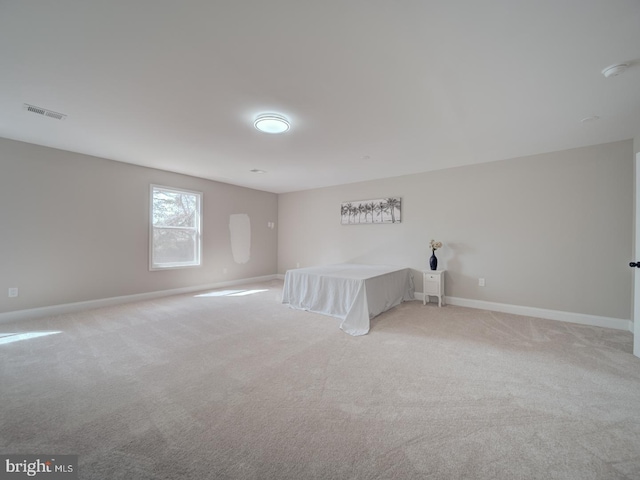 unfurnished bedroom with baseboards, visible vents, and light carpet