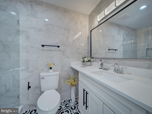 bathroom featuring recessed lighting, toilet, tile walls, and vanity