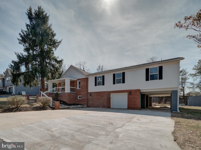 view of front of property featuring brick siding, an attached garage, and driveway