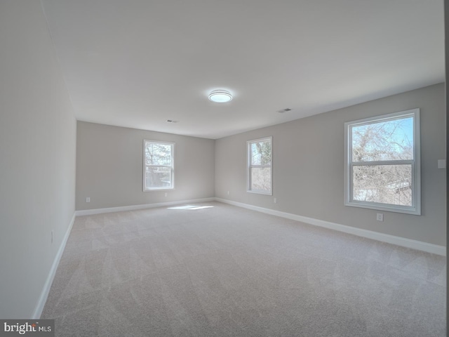 unfurnished room with light carpet and baseboards