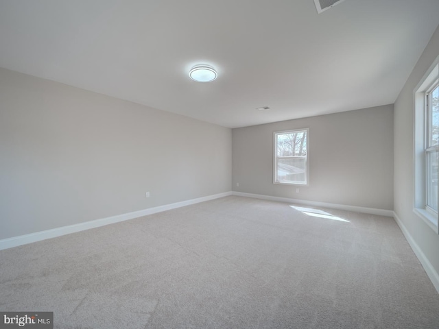 carpeted empty room featuring baseboards