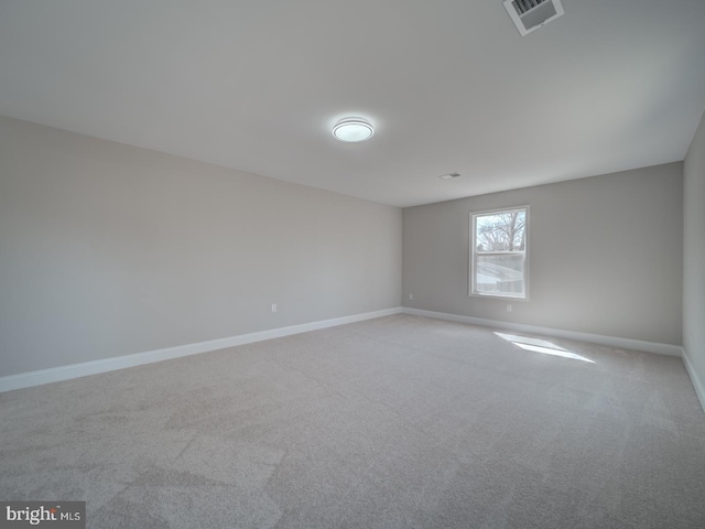 carpeted empty room featuring baseboards and visible vents