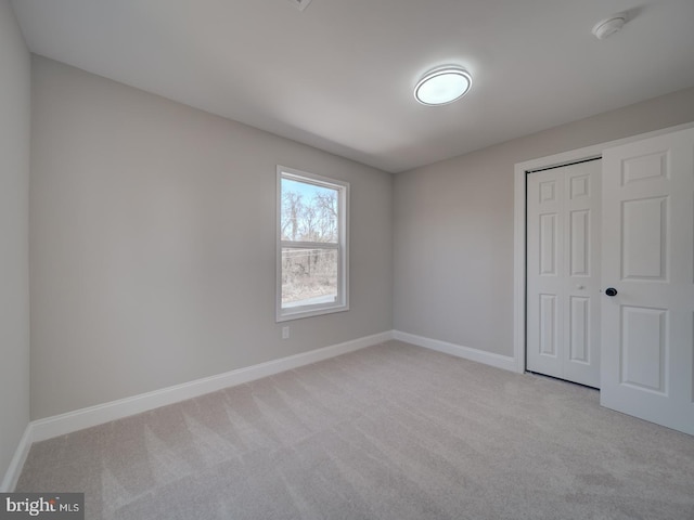 unfurnished bedroom with a closet, baseboards, and carpet floors