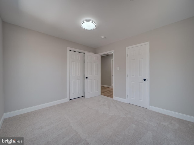 unfurnished bedroom with carpet, baseboards, and a closet