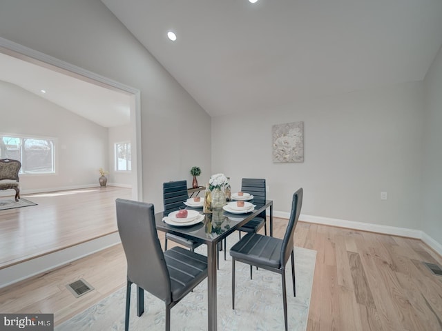 dining room with recessed lighting, baseboards, light wood finished floors, and vaulted ceiling