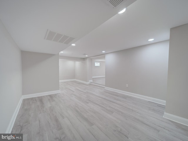 basement with recessed lighting, light wood-type flooring, baseboards, and visible vents