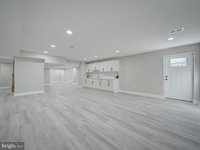 unfurnished living room featuring recessed lighting, visible vents, baseboards, and light wood finished floors