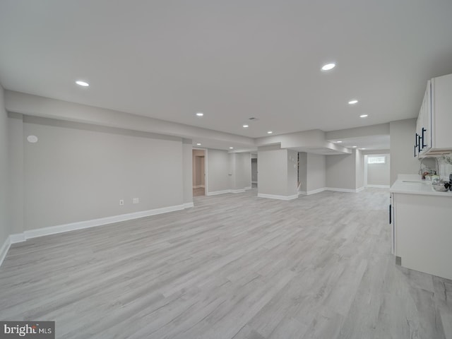 below grade area with recessed lighting, baseboards, and light wood finished floors