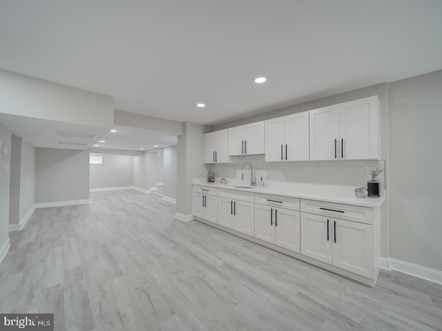 bar with recessed lighting, baseboards, light wood-type flooring, and a sink