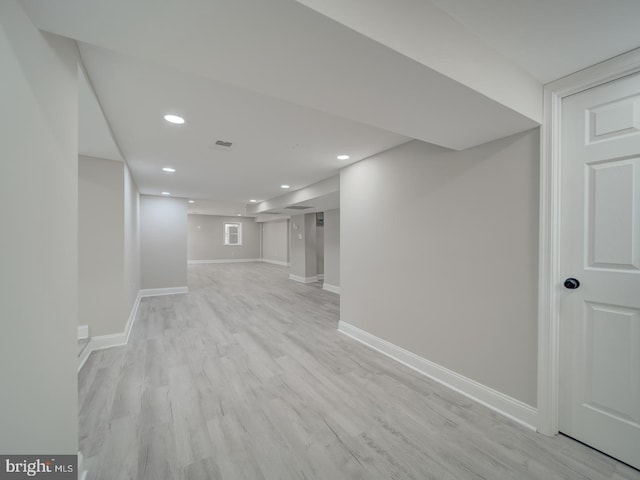 finished below grade area featuring recessed lighting, baseboards, and light wood-style floors