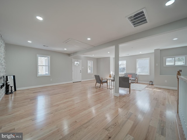 unfurnished living room with attic access, light wood-style flooring, recessed lighting, and visible vents