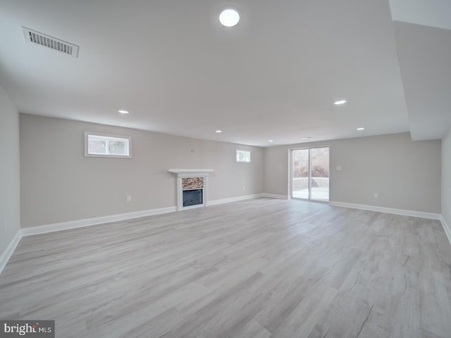 unfurnished living room featuring visible vents, baseboards, recessed lighting, a fireplace, and light wood-style floors