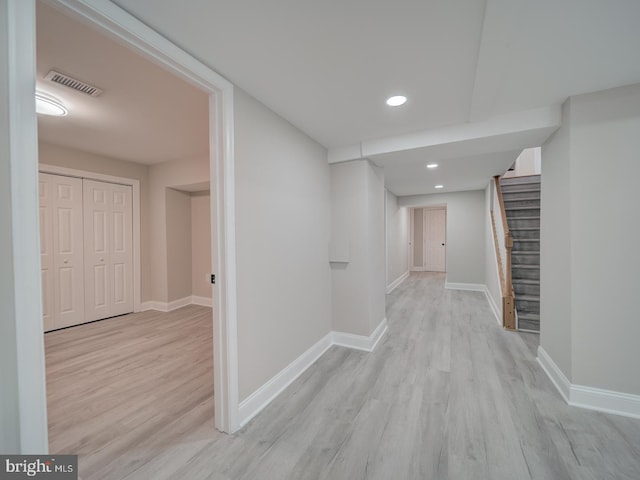 hall featuring visible vents, baseboards, wood finished floors, and stairs