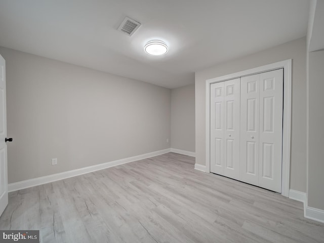 unfurnished bedroom with visible vents, baseboards, a closet, and light wood-style flooring