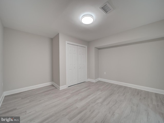 unfurnished bedroom featuring a closet, visible vents, light wood-style flooring, and baseboards