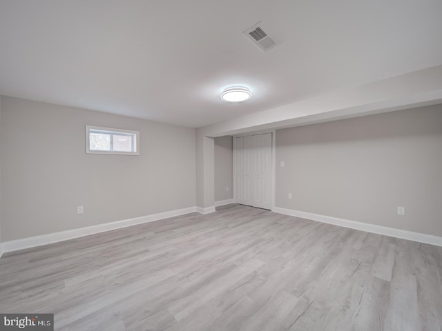 below grade area with visible vents, light wood-style floors, and baseboards