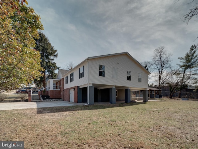 back of house featuring a garage, a lawn, and driveway