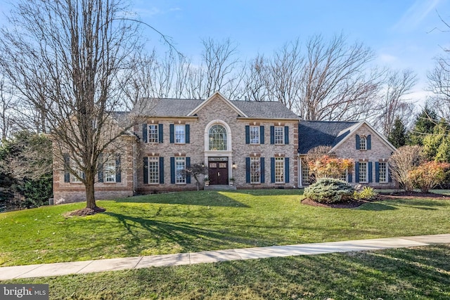 view of front of property featuring brick siding and a front lawn