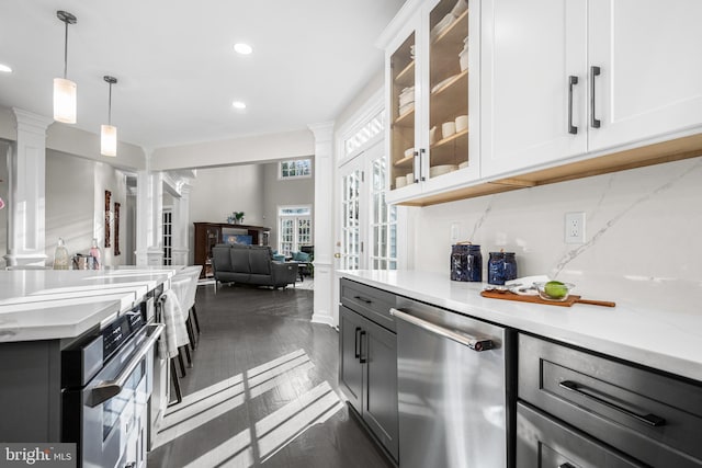 kitchen featuring open floor plan, white cabinetry, decorative backsplash, dishwasher, and ornate columns