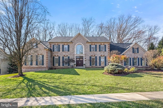 view of front facade featuring brick siding and a front lawn