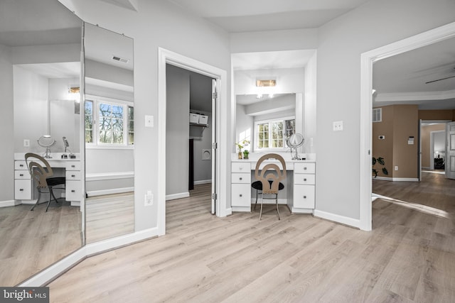 bedroom featuring visible vents, built in study area, baseboards, and wood finished floors