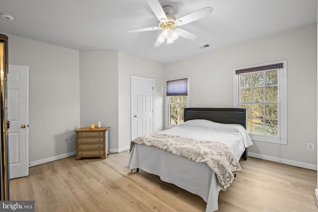 bedroom with baseboards, visible vents, light wood finished floors, and ceiling fan