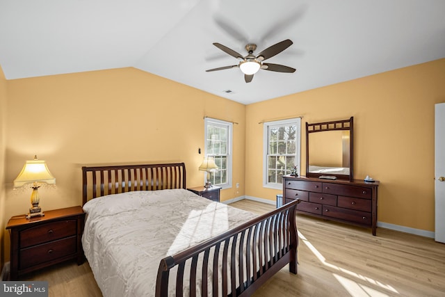 bedroom with visible vents, baseboards, lofted ceiling, and wood finished floors