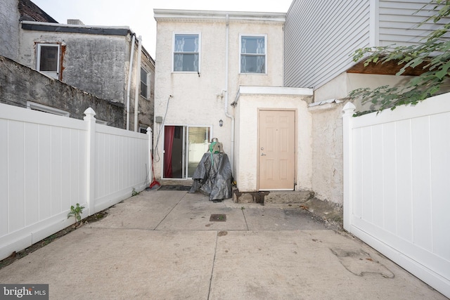 back of house featuring a patio area, fence, and stucco siding