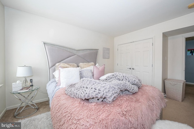 bedroom with carpet, a closet, and baseboards