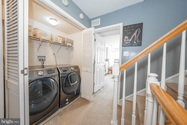 washroom featuring carpet flooring, laundry area, visible vents, and washing machine and clothes dryer